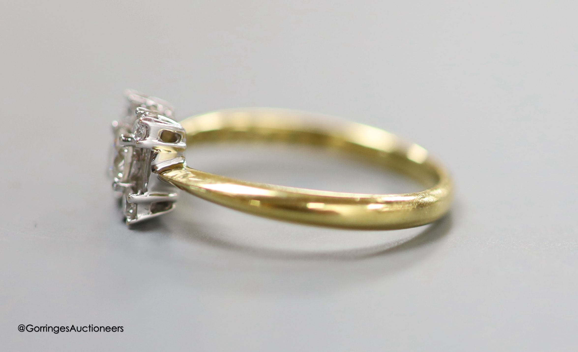 A modern 18ct gold, round and baguette cut diamond set square cluster ring, size N, gross 2.8 grams.